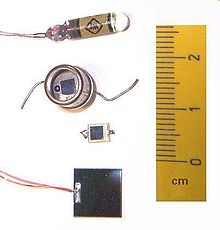 Photodiode semiconductor component with transparent window showing p-n junction light-sensitive area, two wire leads for electrical connection, used in precise light detection applications requiring faster response time and linear output compared to photoresistors